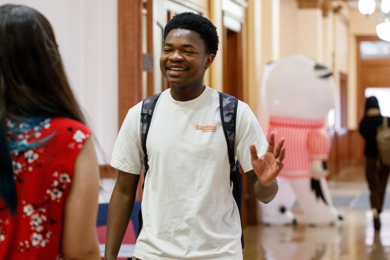 Student, smiling, meeting with an academic advisor